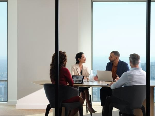 Grupo reduzido mantém uma conversa de trabalho em uma sala reservada.